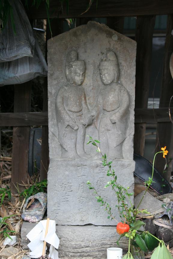 男女の神像が向合い、互いに手をつないでいる羽尾道祖神の写真