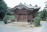 周辺に木が生い茂っている中で福田馬頭観音が安置された建物の写真
