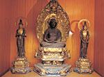 左右に1体ずつ置かれた小さな像と中央に大きめな像が置かれている木造阿弥陀如来坐像の写真