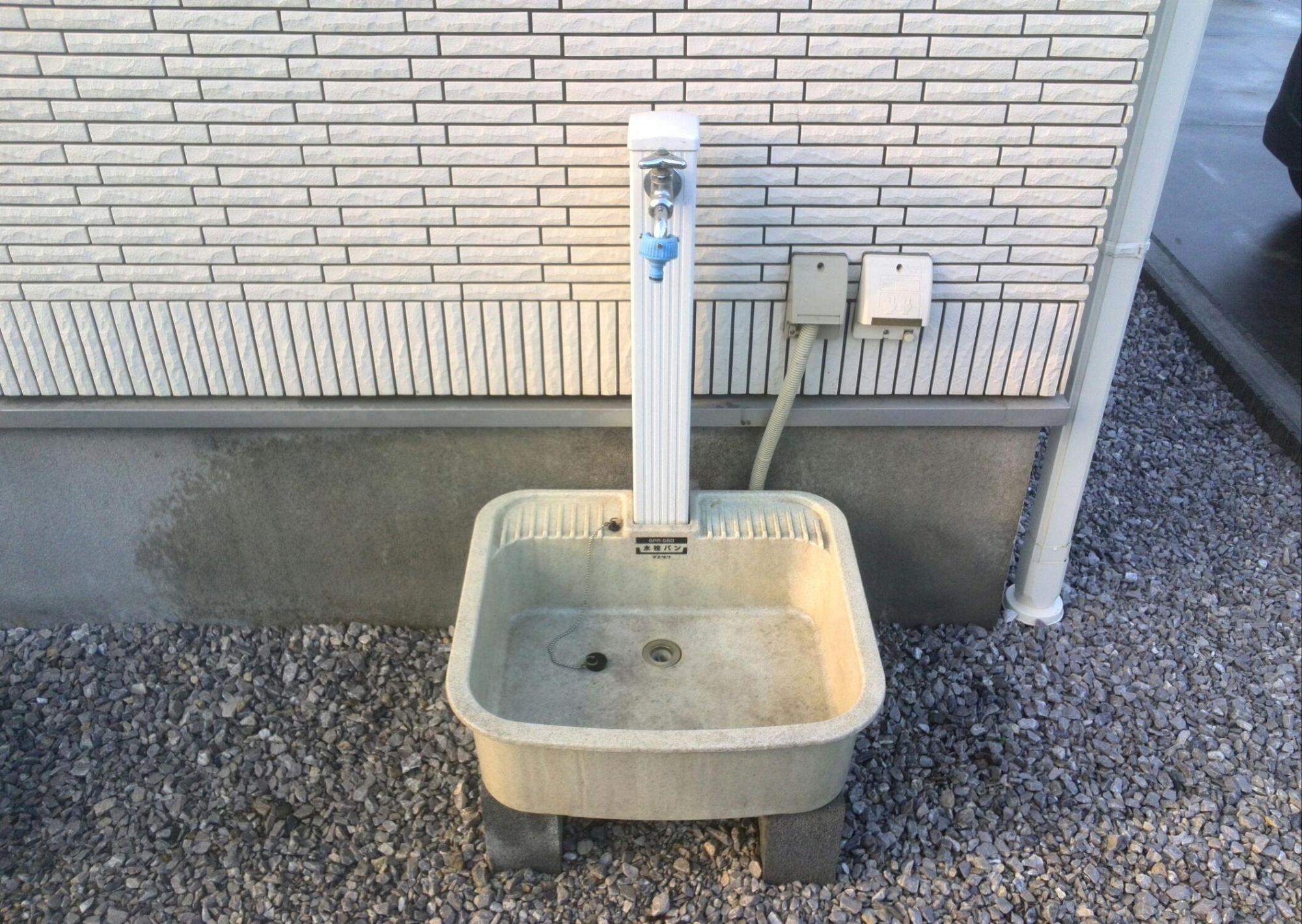 家の外壁沿いに設置されている外水道の写真