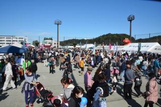 滑川町総合運動公園でおこなわれた滑川まつりに出店しているテントやパラソルが張られた模擬店に集まる数多くの参加者たちの写真